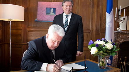 Signature du livre d’or par Yves Tavernier, C.Q., en compagnie du délégué général du Québec à Paris, Michel Robitaille.